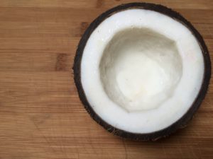 Halbierte Kokosnuss auf Holztisch