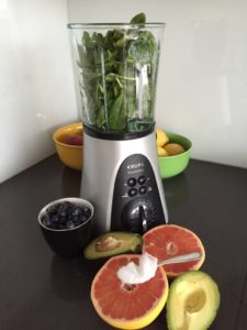 Hochleistungsmixer mit frischem Obst, Gemüse und Kokosöl