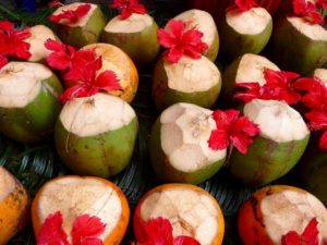 Frische grüne Kokosnüsse mit roten Blüten